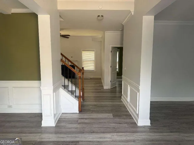 a view of a hallway with wooden floor and staircase