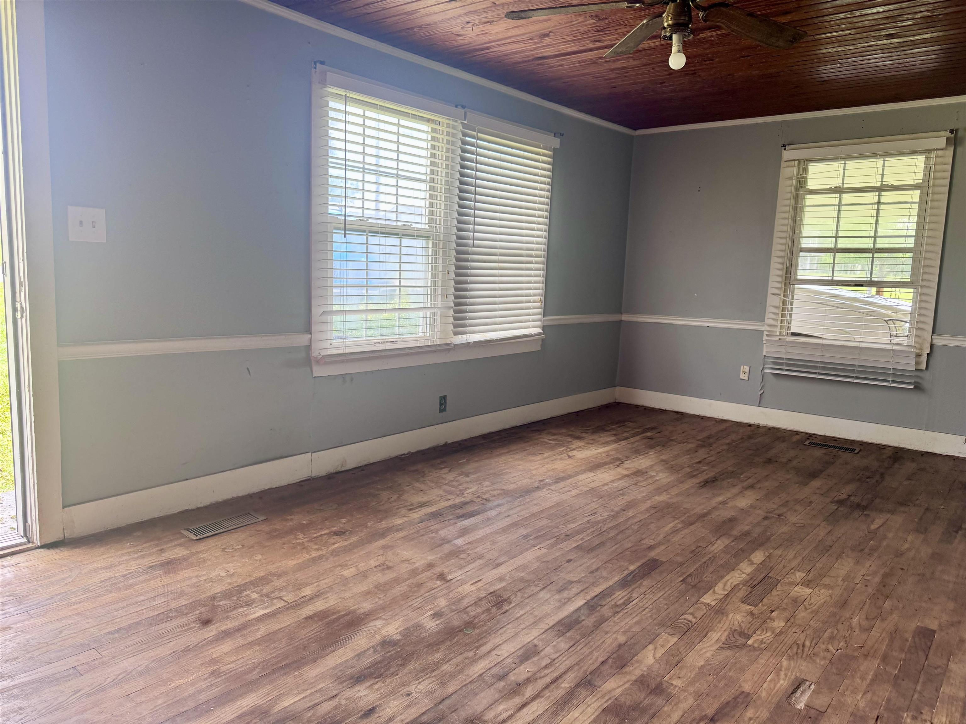 237 Old Shiloh Road Adamsville, TN 38310 - Photo 2 of 11 an empty room with wooden floor and windows