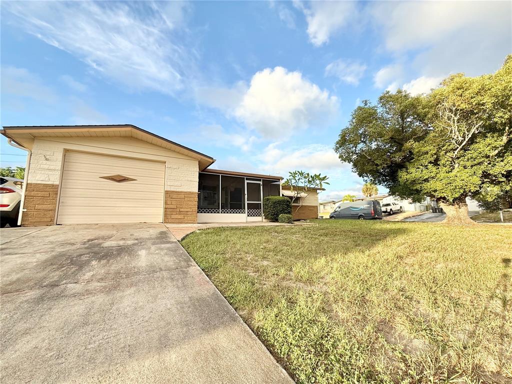 4935 Guardian Avenue Holiday, FL 34690 - Photo 2 of 32 a front view of a house with a yard and garage