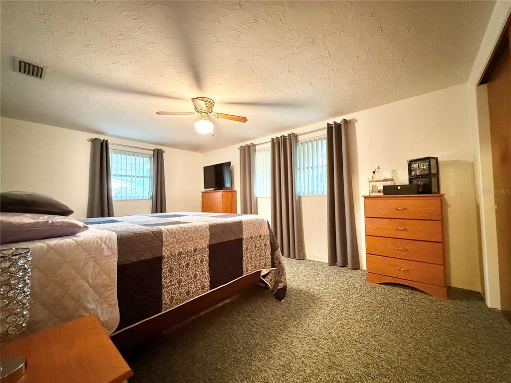 4935 Guardian Avenue Holiday, FL 34690 - Photo 22 of 32 a bed room with a bed and a dresser