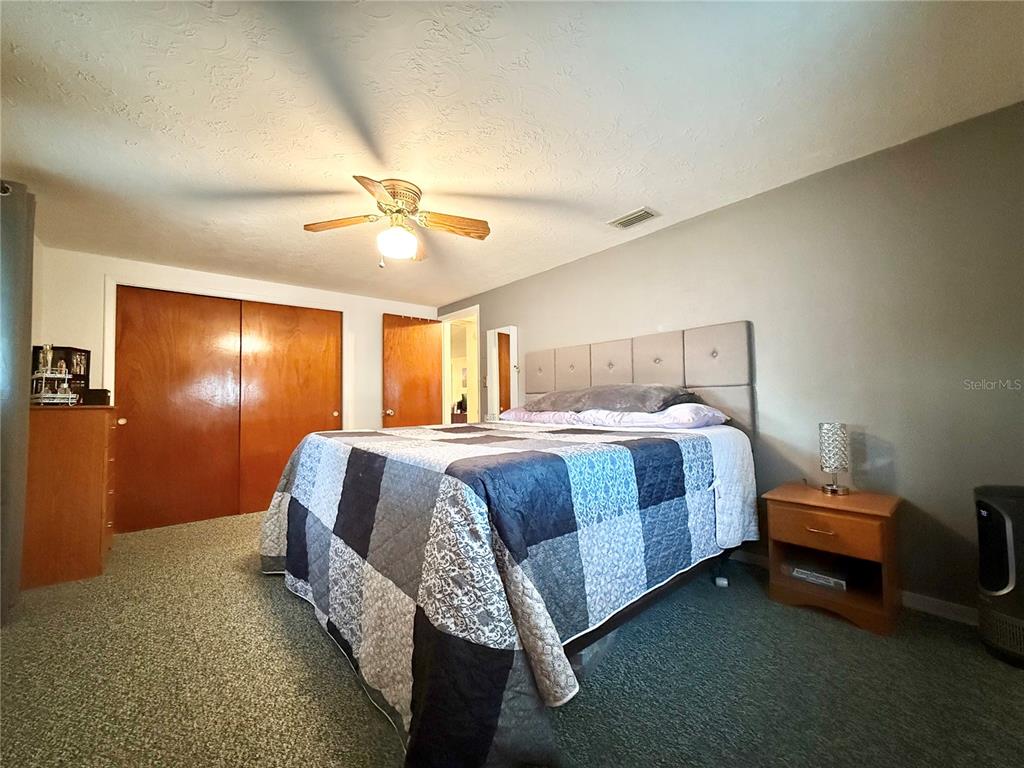 4935 Guardian Avenue Holiday, FL 34690 - Photo 23 of 32 a bed room with a bed and a chandelier