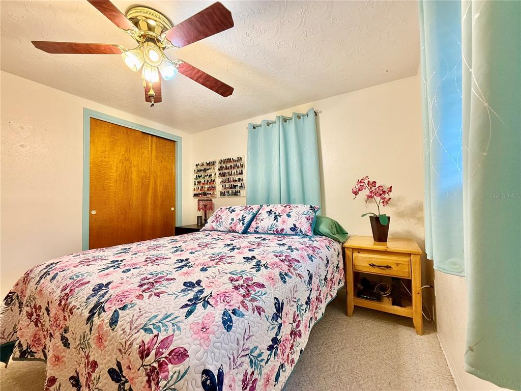 4935 Guardian Avenue Holiday, FL 34690 - Photo 25 of 32 a bedroom with a bed and a chandelier