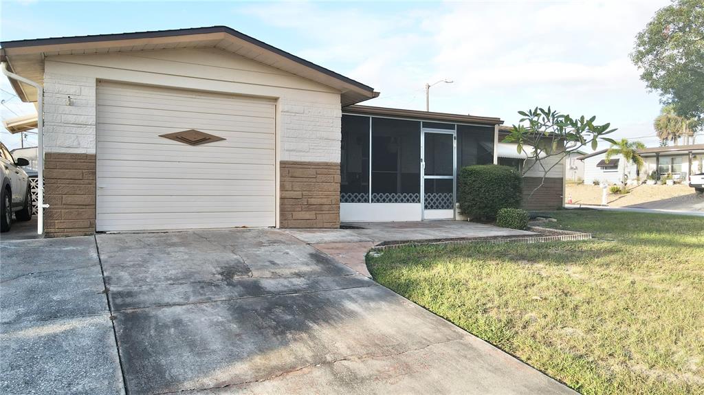 4935 Guardian Avenue Holiday, FL 34690 - Photo 3 of 32 a front view of a house with garden