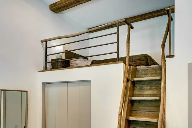 a bedroom with a bed a couch and a flat tv screen