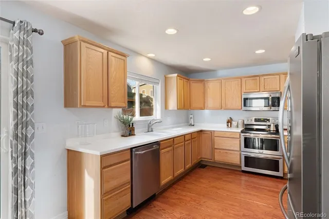 a kitchen with a sink cabinets stainless steel appliances and a window