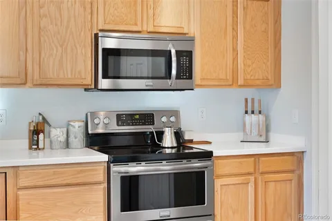 a kitchen with stainless steel appliances granite countertop white cabinets and a stove top oven