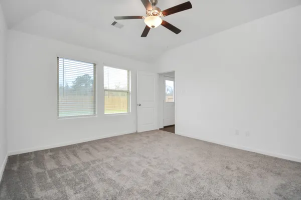 an empty room with windows and fan