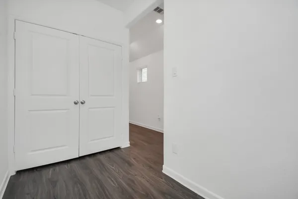 a view of an empty room with wooden floor