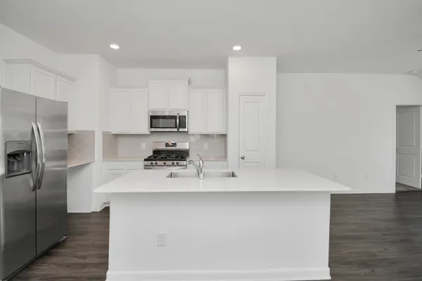 a view of a kitchen with white cabinets and stainless steel appliances
