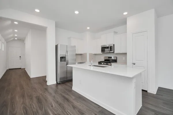 a kitchen with stainless steel appliances a refrigerator stove a sink and a oven