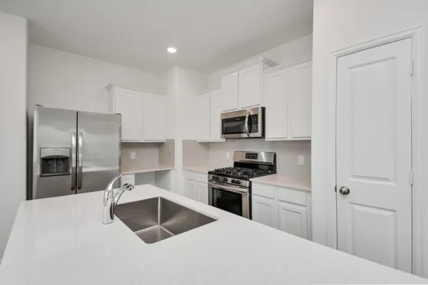 a kitchen with a sink a stove and refrigerator