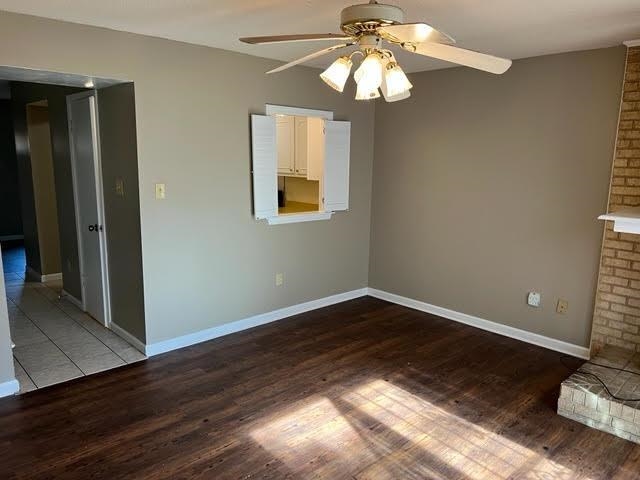 4795 Winchester Road Memphis, TN 38118 - Photo 5 of 7 Living area featuring wood-finish flooring, a brick fireplace with a white mantel, and a ceiling fan with integrated lighting