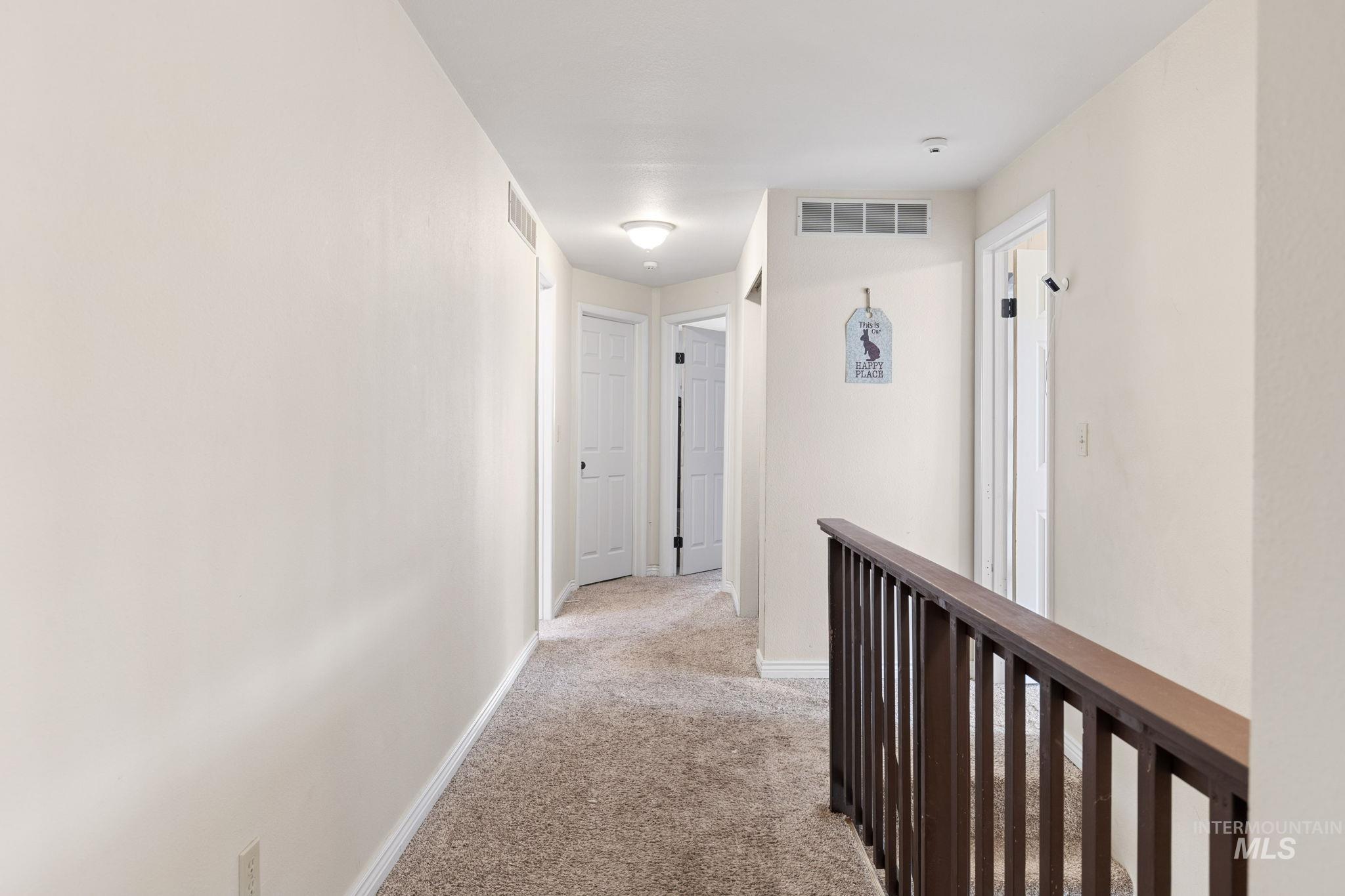 18338 Pride Lane Caldwell, ID 83607 - Photo 22 of 50 Carpeted hallway with light neutral walls and white trim