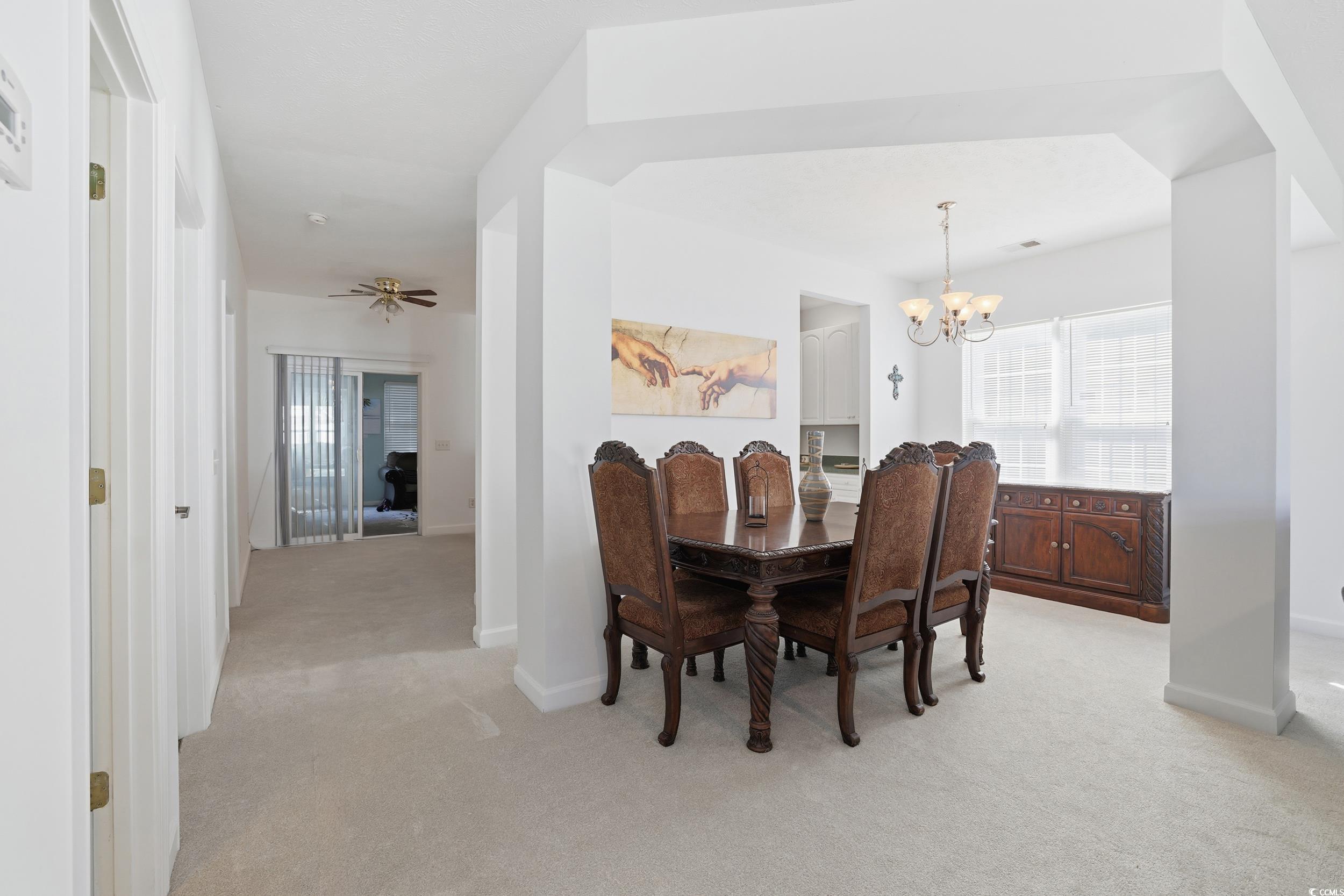 309 Meadowside Drive Little River, SC 29566 - Photo 11 of 40 Dining room with light carpet, a chandelier, and ceiling fan