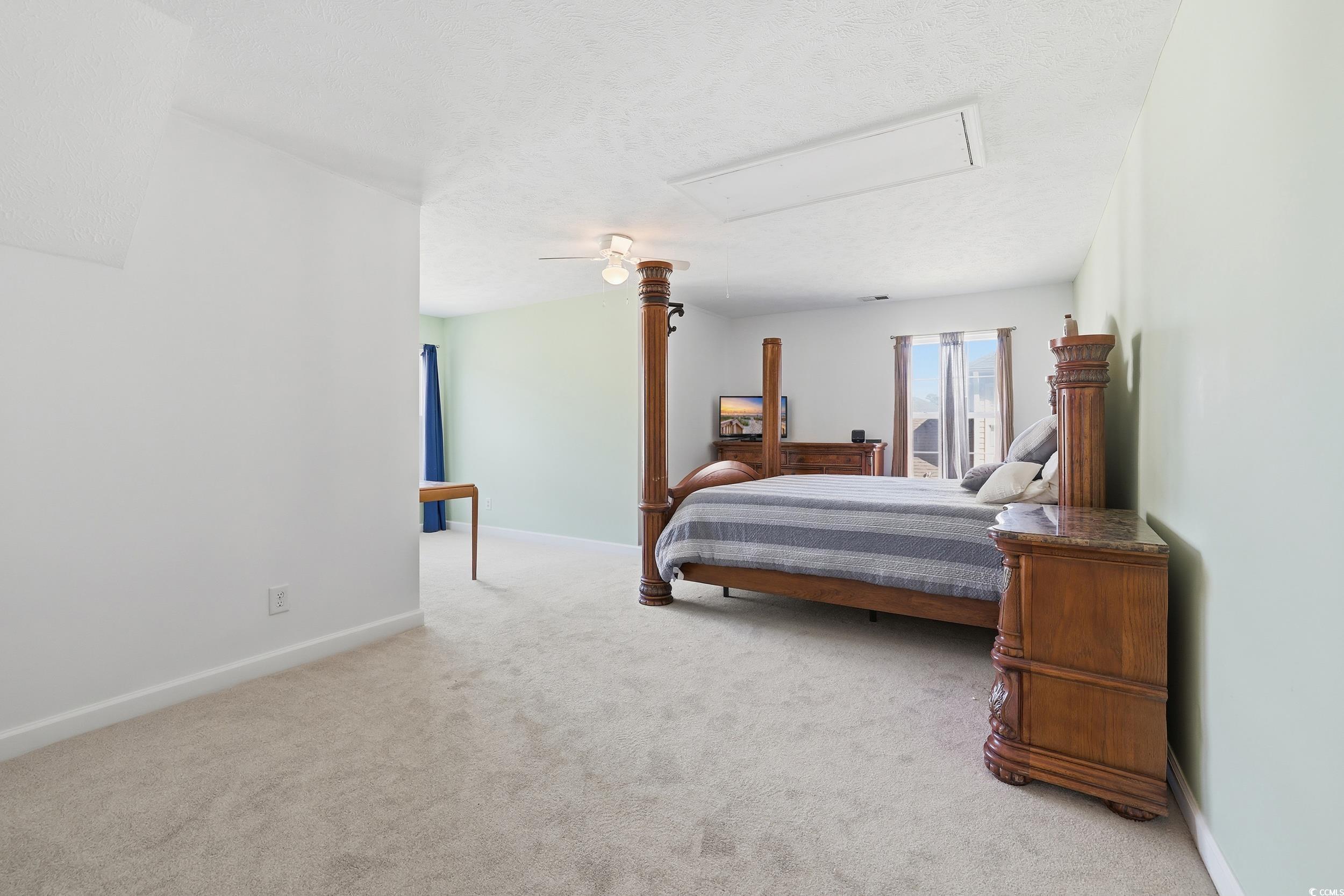 309 Meadowside Drive Little River, SC 29566 - Photo 20 of 40 Bedroom featuring light colored carpet, a textured ceiling, and attic access