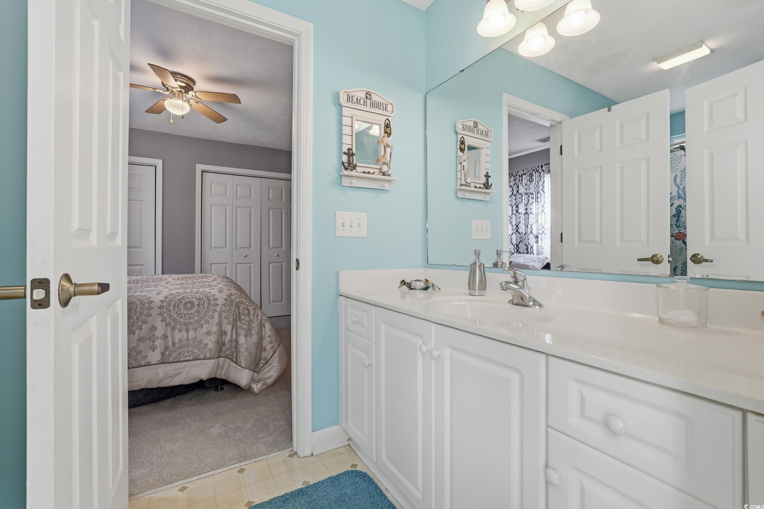309 Meadowside Drive Little River, SC 29566 - Photo 24 of 40 Ensuite bathroom with vanity, light carpet, curtained shower, and a ceiling fan