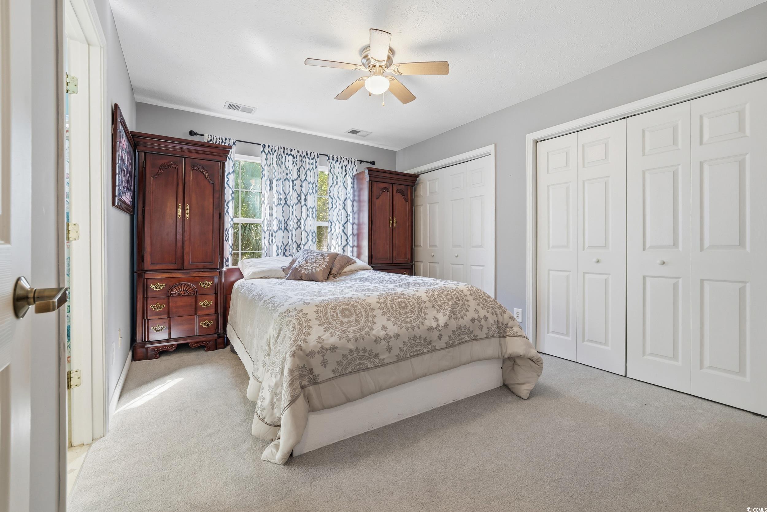 309 Meadowside Drive Little River, SC 29566 - Photo 27 of 40 Bedroom with two closets, light colored carpet, and a ceiling fan