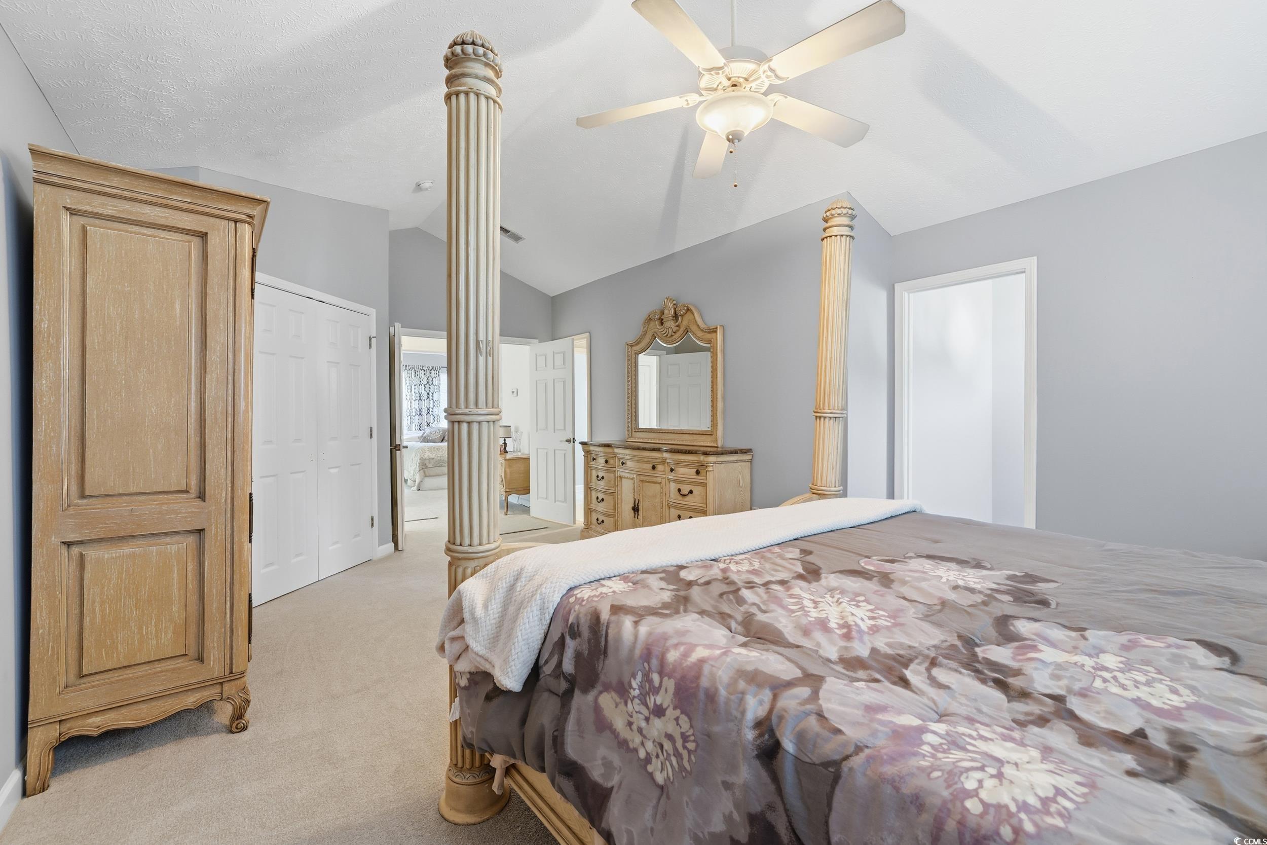 309 Meadowside Drive Little River, SC 29566 - Photo 29 of 40 Bedroom featuring a closet, light colored carpet, vaulted ceiling, a ceiling fan, and ornate columns