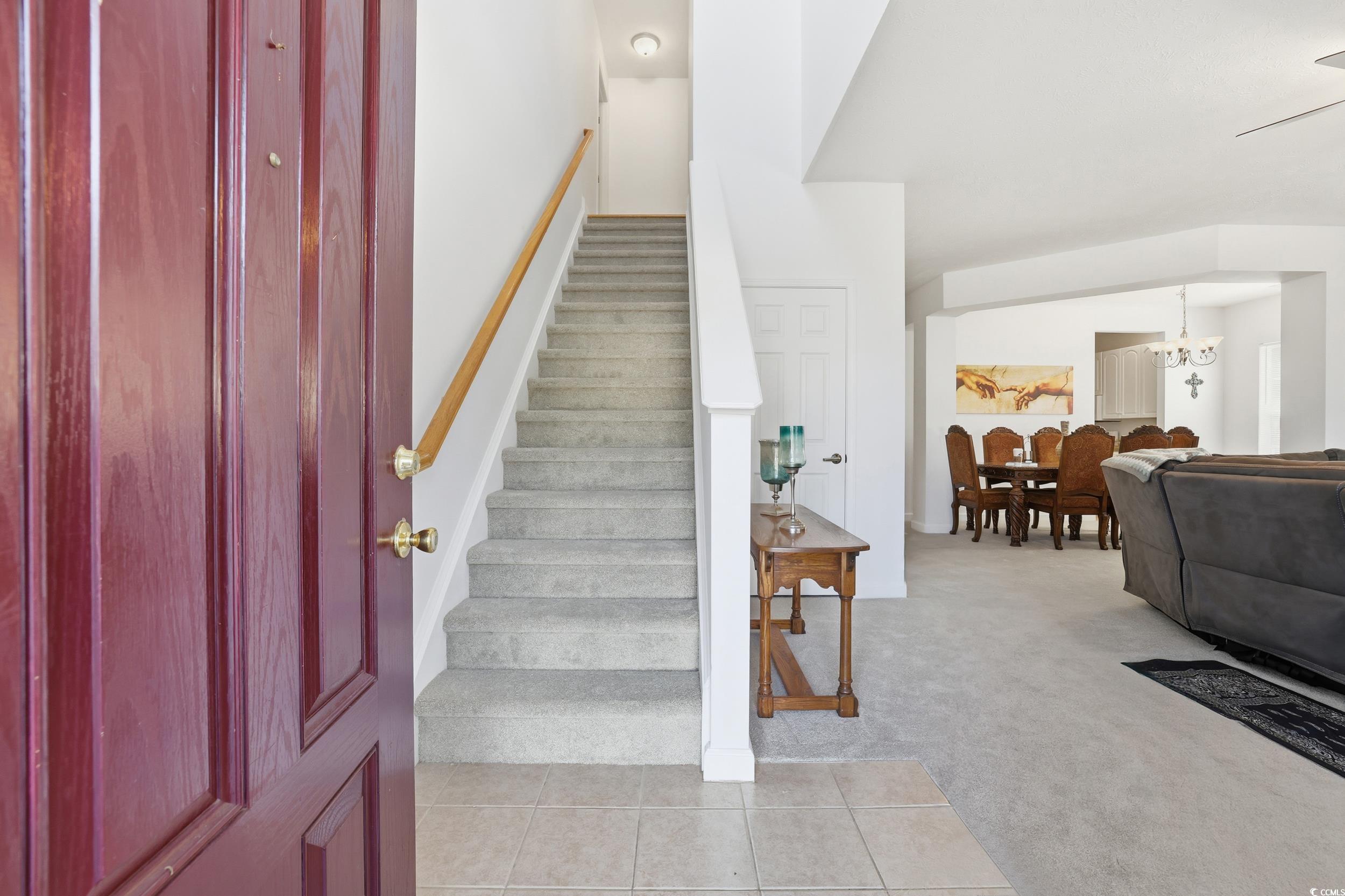 309 Meadowside Drive Little River, SC 29566 - Photo 6 of 40 Staircase with carpet, tile patterned floors, a chandelier, and ceiling fan
