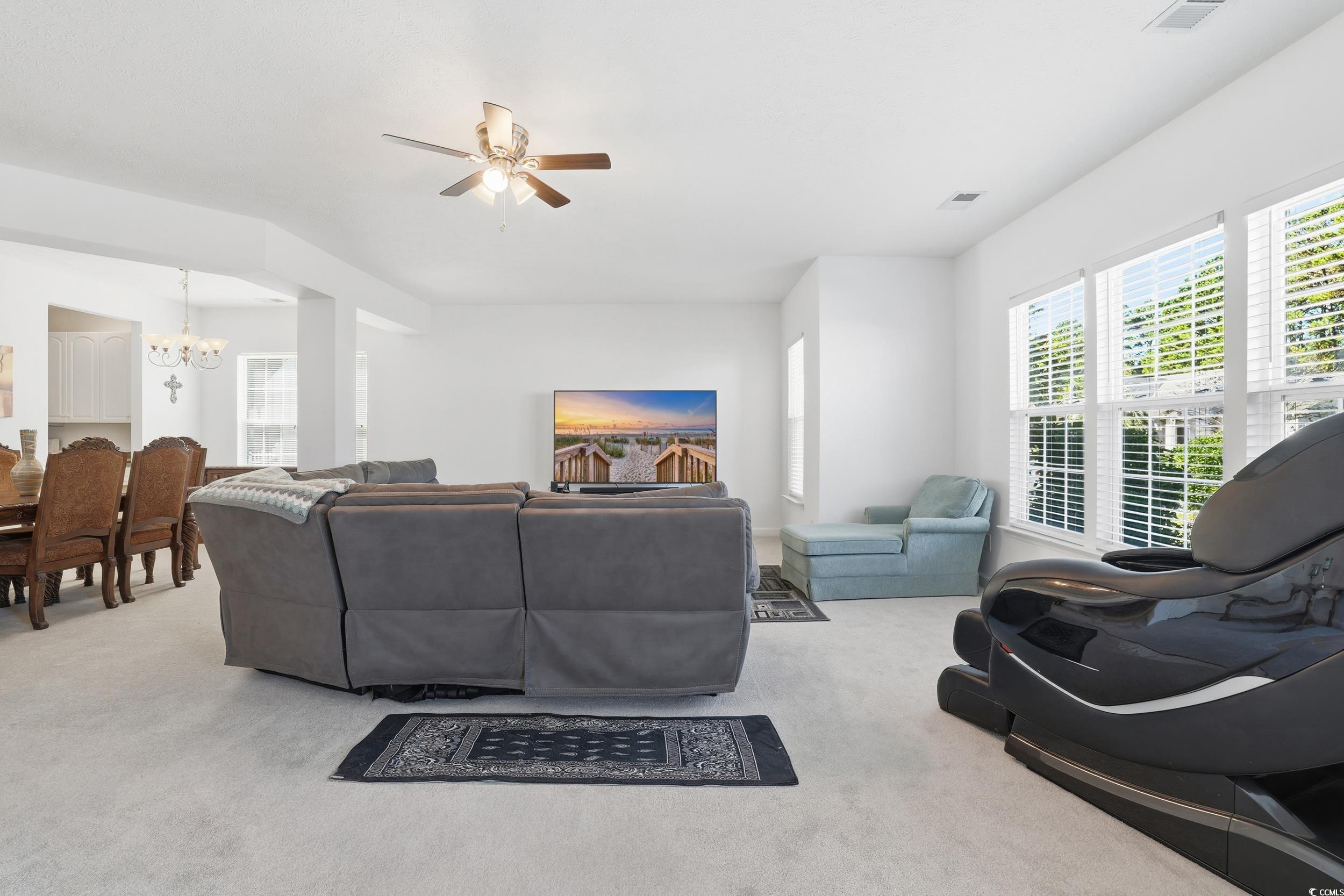 309 Meadowside Drive Little River, SC 29566 - Photo 7 of 40 Living area with light colored carpet, a chandelier, and ceiling fan