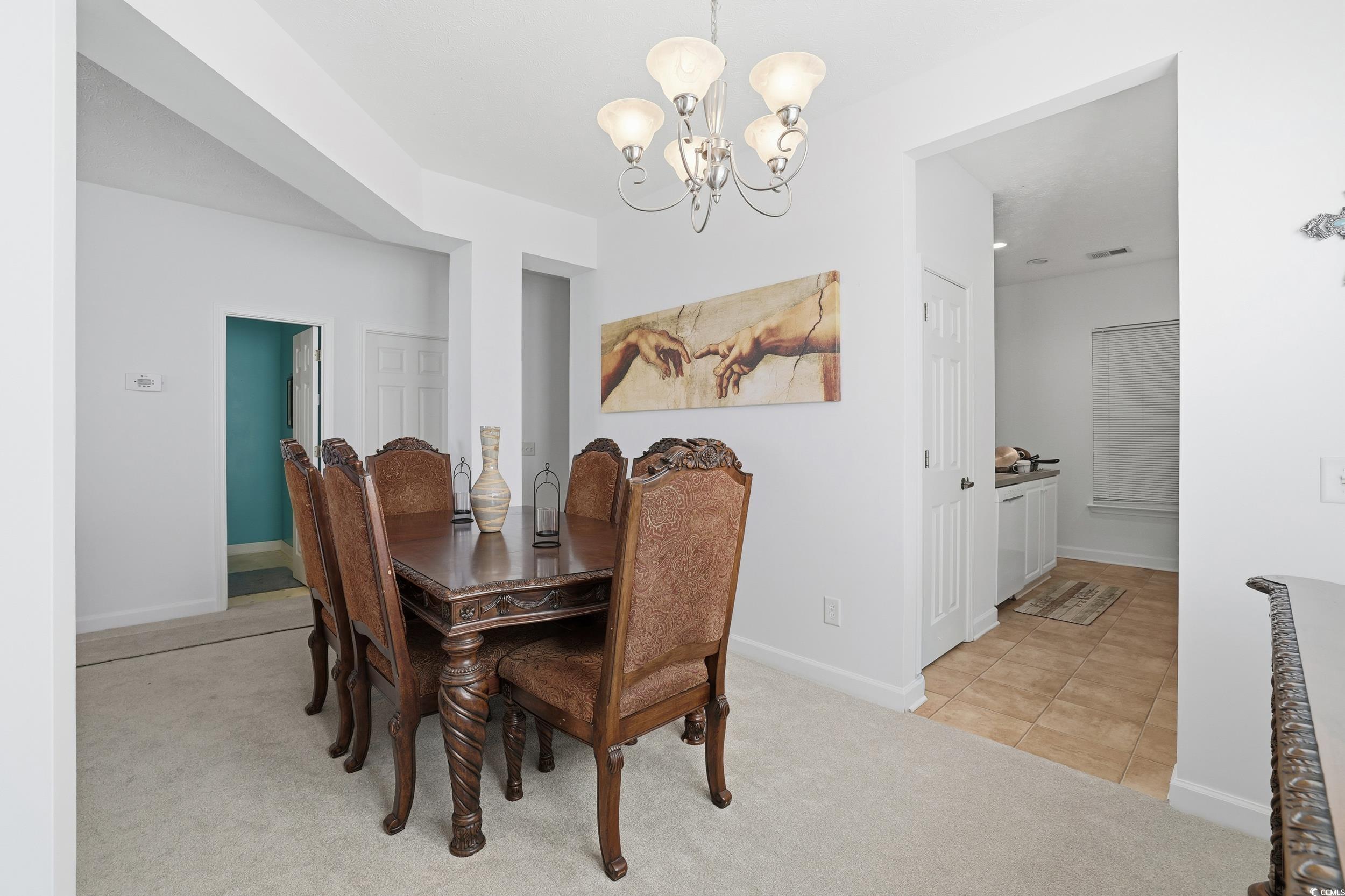 309 Meadowside Drive Little River, SC 29566 - Photo 10 of 40 Dining space featuring light colored carpet, a chandelier, and light tile patterned floors