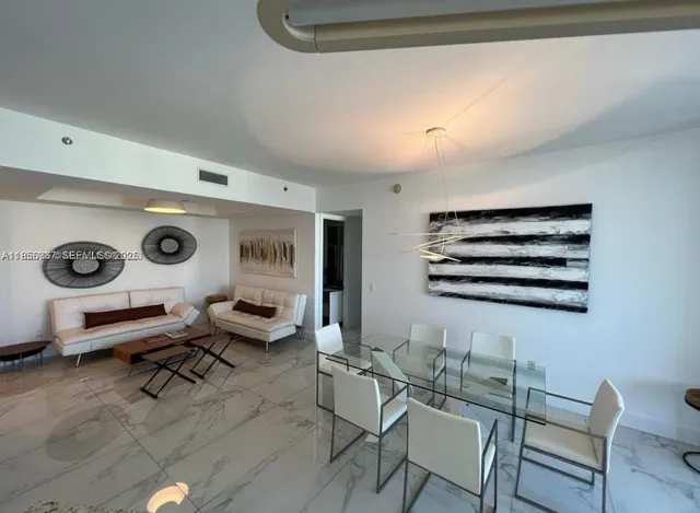 a view of a hallway with seating area and white walls