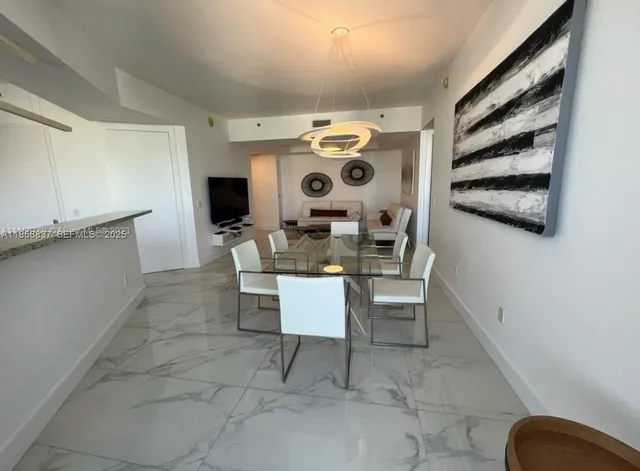 a dining room with furniture and large windows