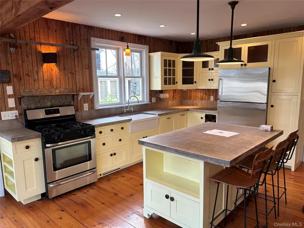 a kitchen with stainless steel appliances kitchen island a table and chairs in it