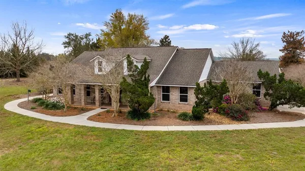 a view of a house with pool and sitting area