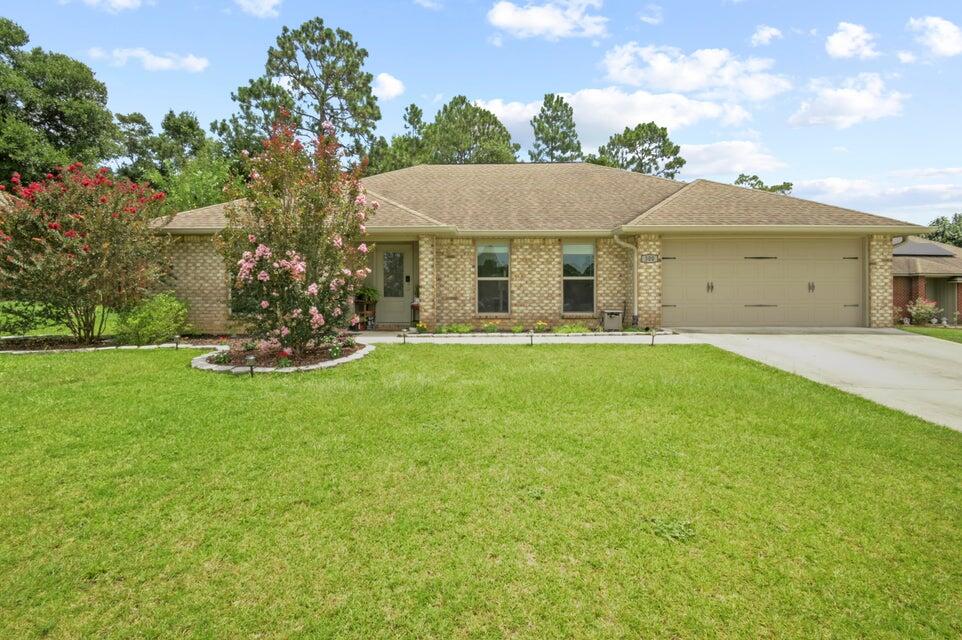 300 Cassady Lane Crestview, FL 32539 - Photo 1 of 25 a front view of a house with a garden and yard