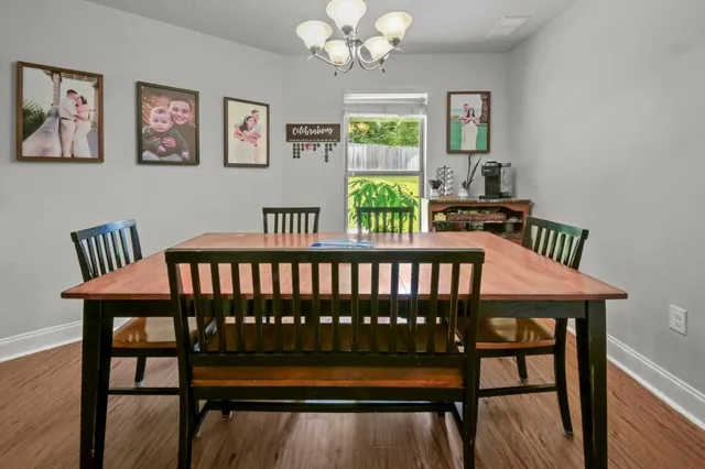 a view of a dining room with furniture a chandelier and wooden floor