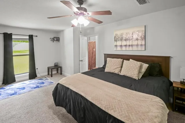 a bedroom with a large bed and a chandelier