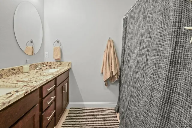 a bathroom with a granite countertop sink a shower and a mirror