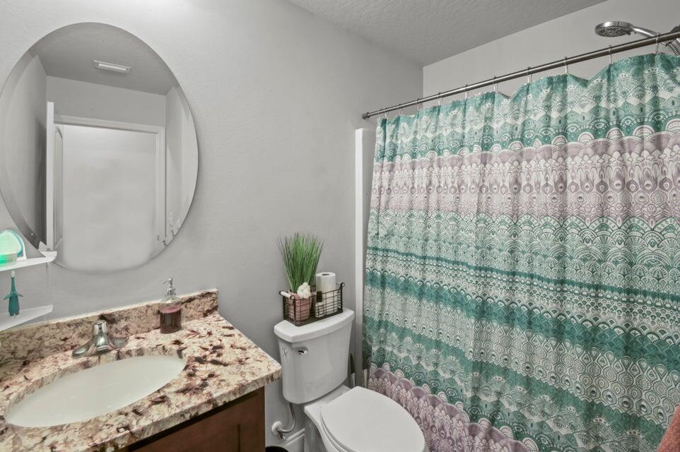 300 Cassady Lane Crestview, FL 32539 - Photo 20 of 25 a bathroom with a granite countertop sink a toilet and a mirror