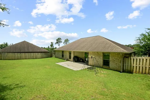 a view of a house with backyard and sitting area