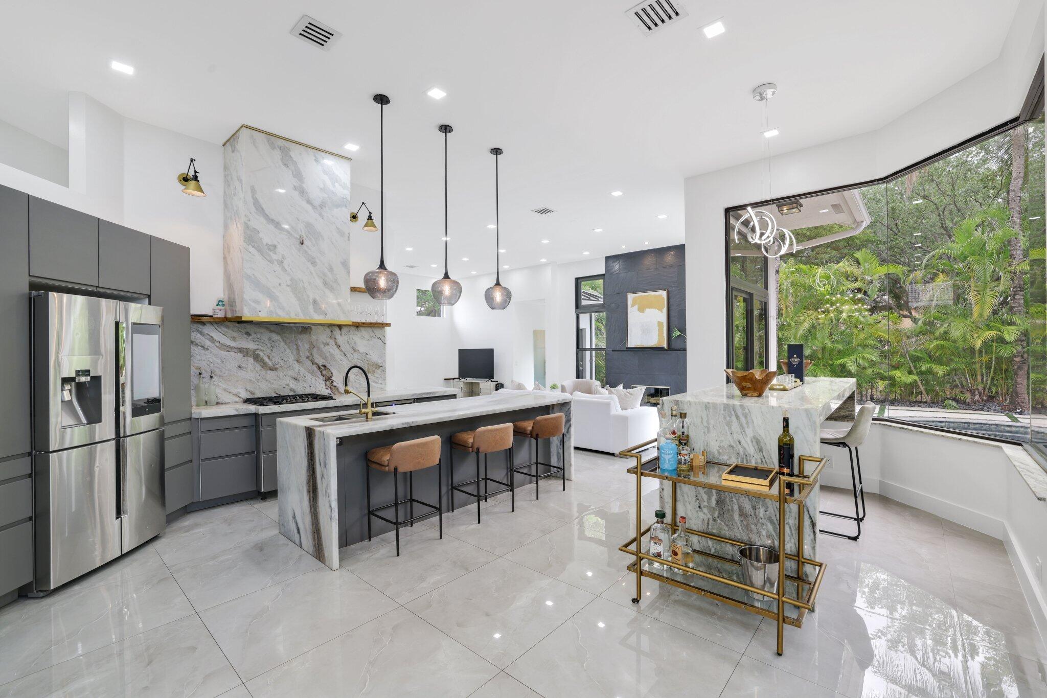 4265 Southwest 185th Avenue Miramar, FL 33029 - Photo 17 of 64 a kitchen with stainless steel appliances granite countertop table chairs sink and cabinets