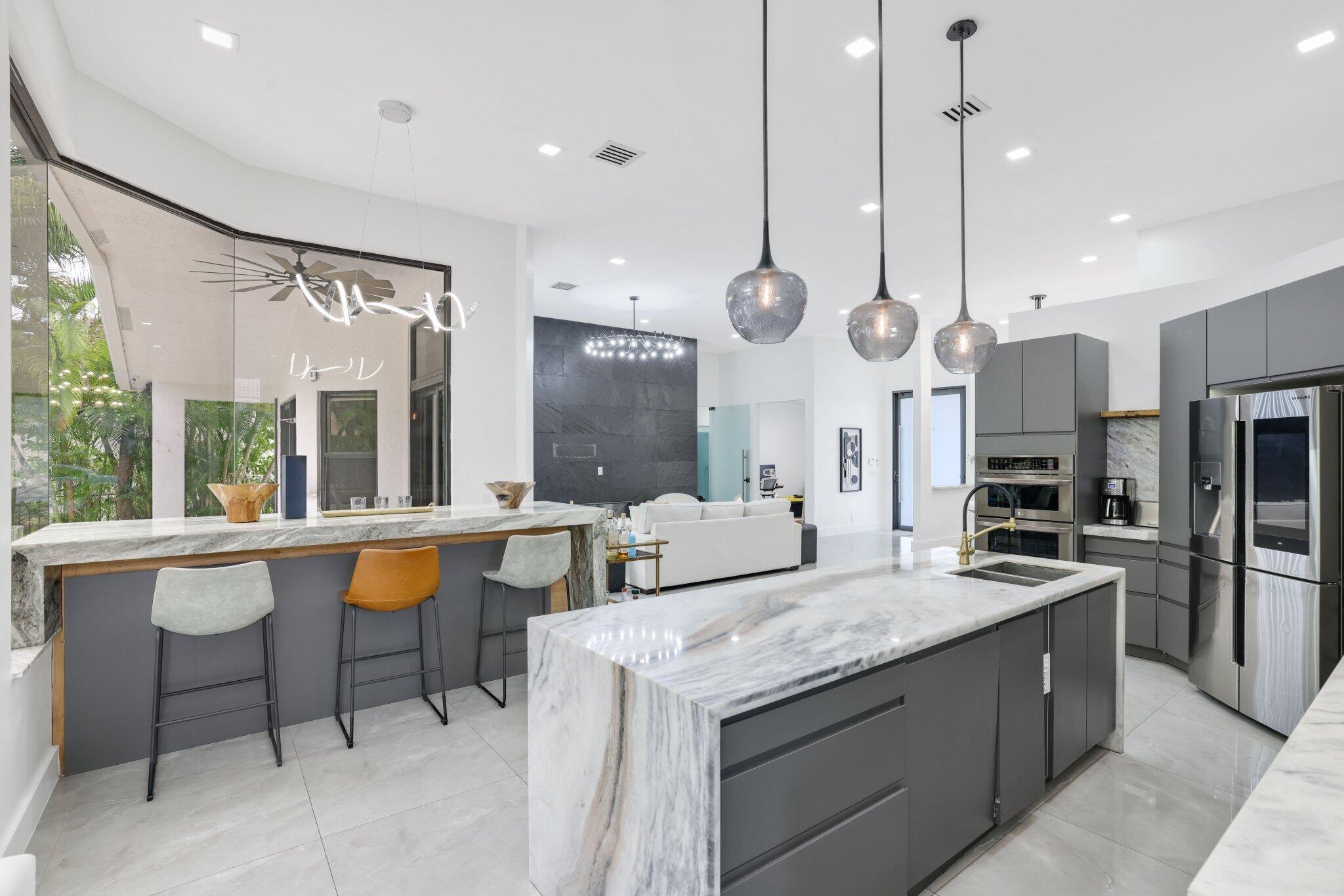 4265 Southwest 185th Avenue Miramar, FL 33029 - Photo 19 of 64 a large kitchen with granite countertop a stove a sink a island and chairs