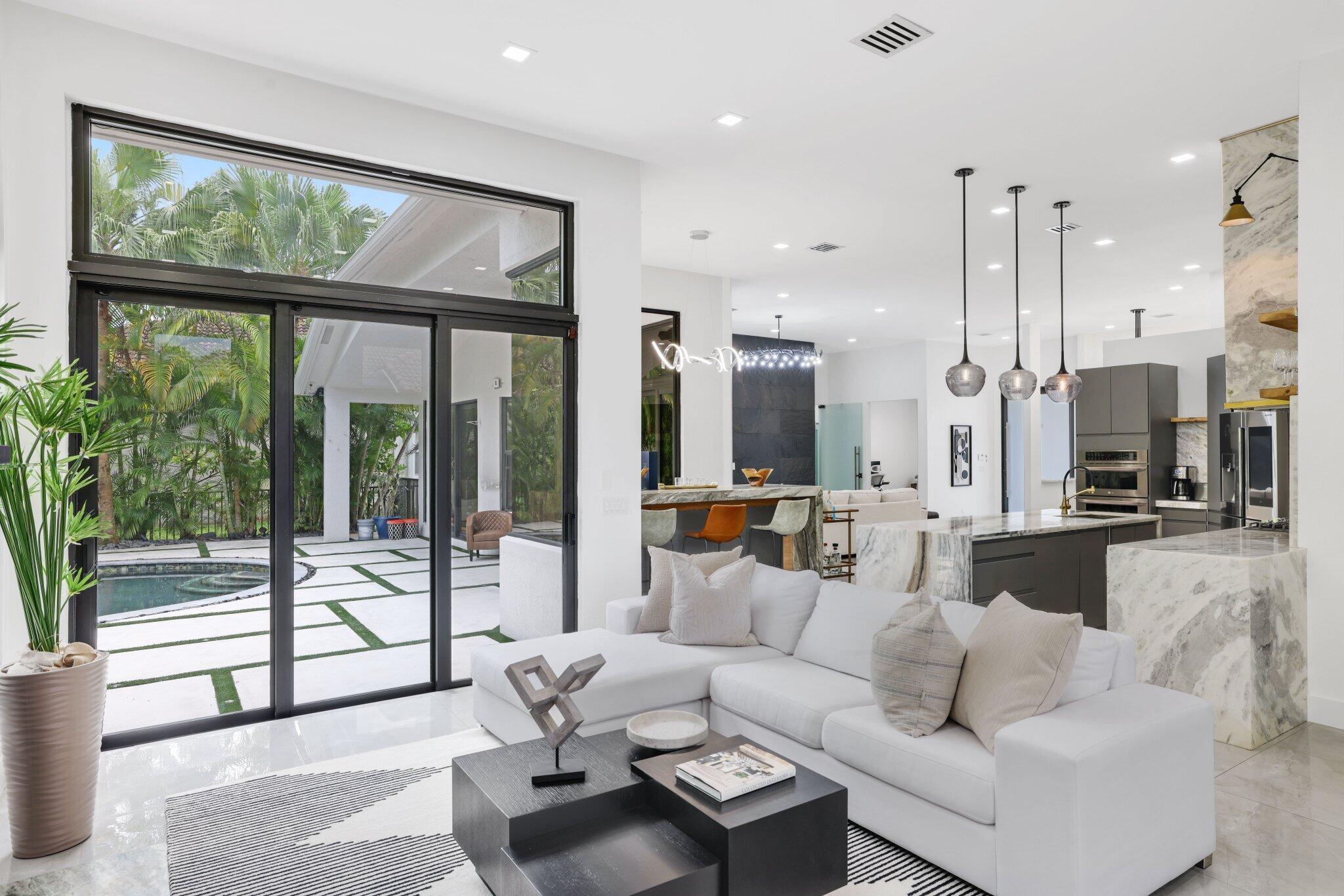 4265 Southwest 185th Avenue Miramar, FL 33029 - Photo 28 of 64 a living room with furniture large windows a rug and a chandelier