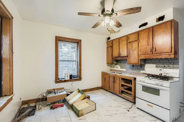 a kitchen with stainless steel appliances a stove a sink cabinets and a window