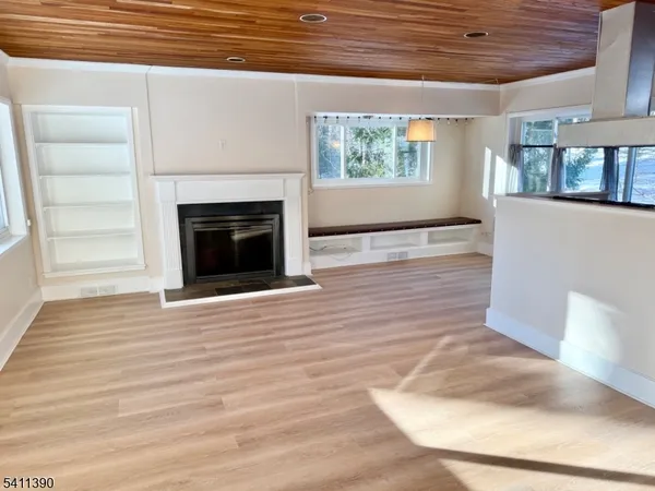 a view of a livingroom with wooden floor and a fireplace