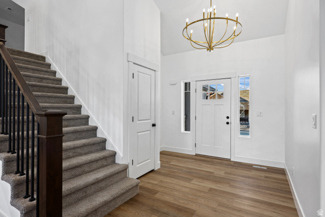 1139 South 4475 West West Point, UT 84015 - Photo 5 of 33 Entryway featuring wood finished floors, stairway, a chandelier, and a towering ceiling
