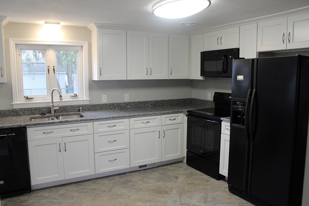 154 Carnavon Circle Springfield, MA 01109 - Photo 3 of 17 a kitchen with granite countertop white cabinets and refrigerator
