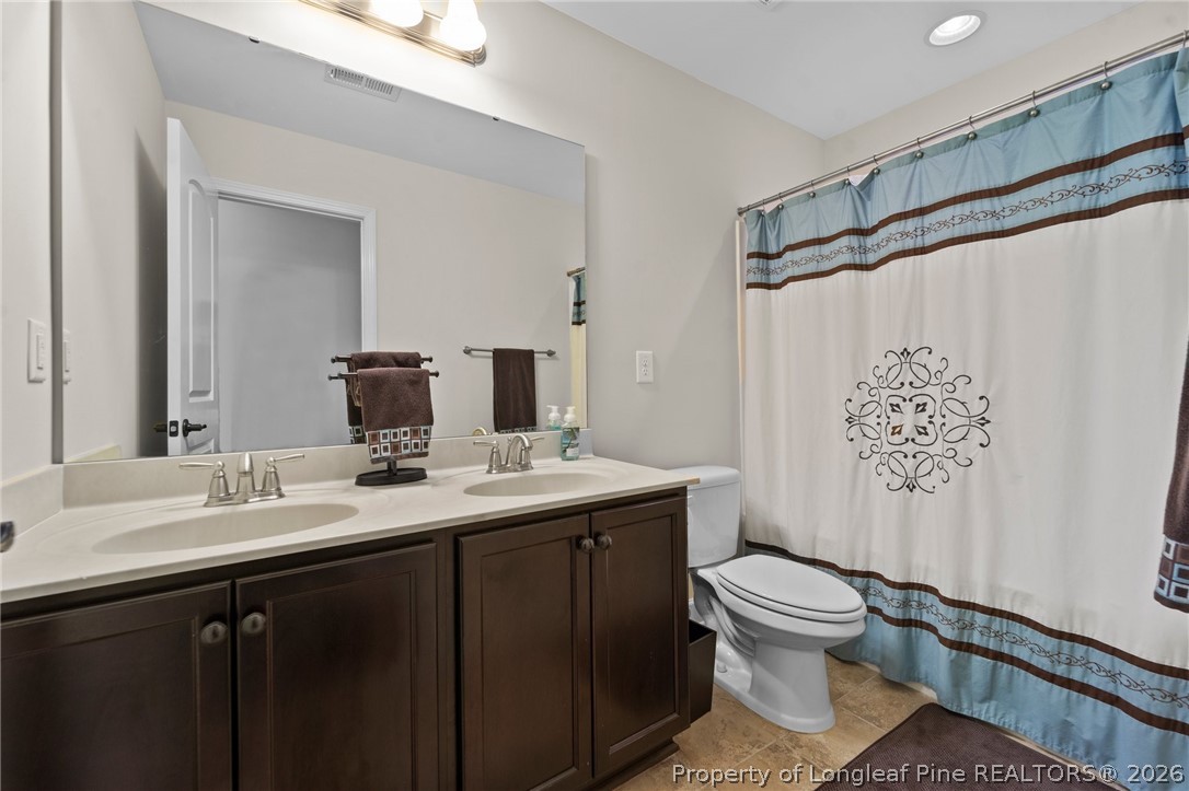 141 Pine Hawk Drive Spring Lake, NC 28390 - Photo 17 of 21 a bathroom with a granite countertop sink toilet and shower