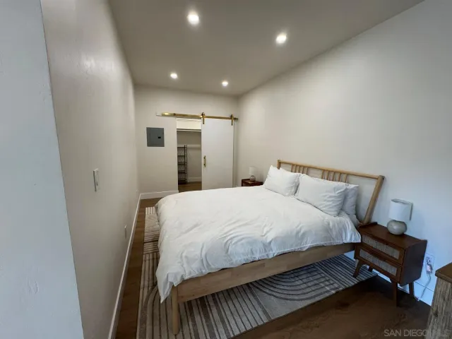 a spacious bedroom with a bed and a dresser