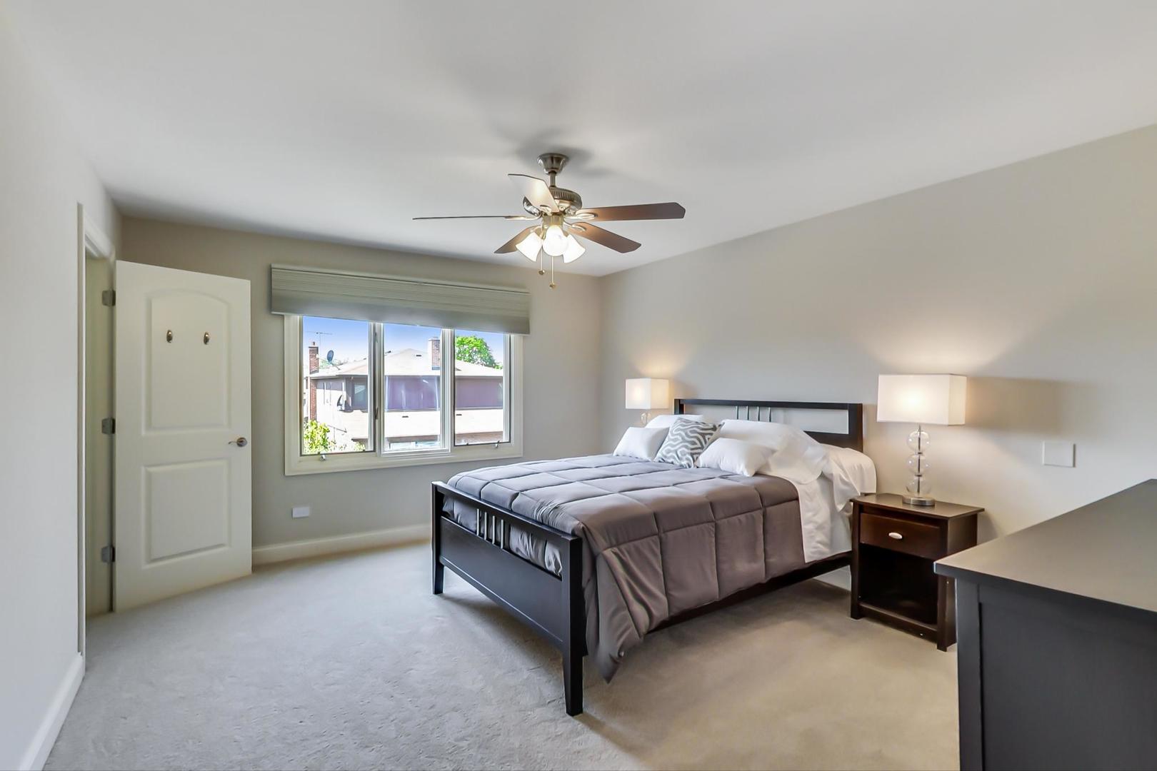 1136 North Greenwood Avenue Park Ridge, IL 60068 - Photo 13 of 30 a spacious bedroom with a bed and a ceiling fan
