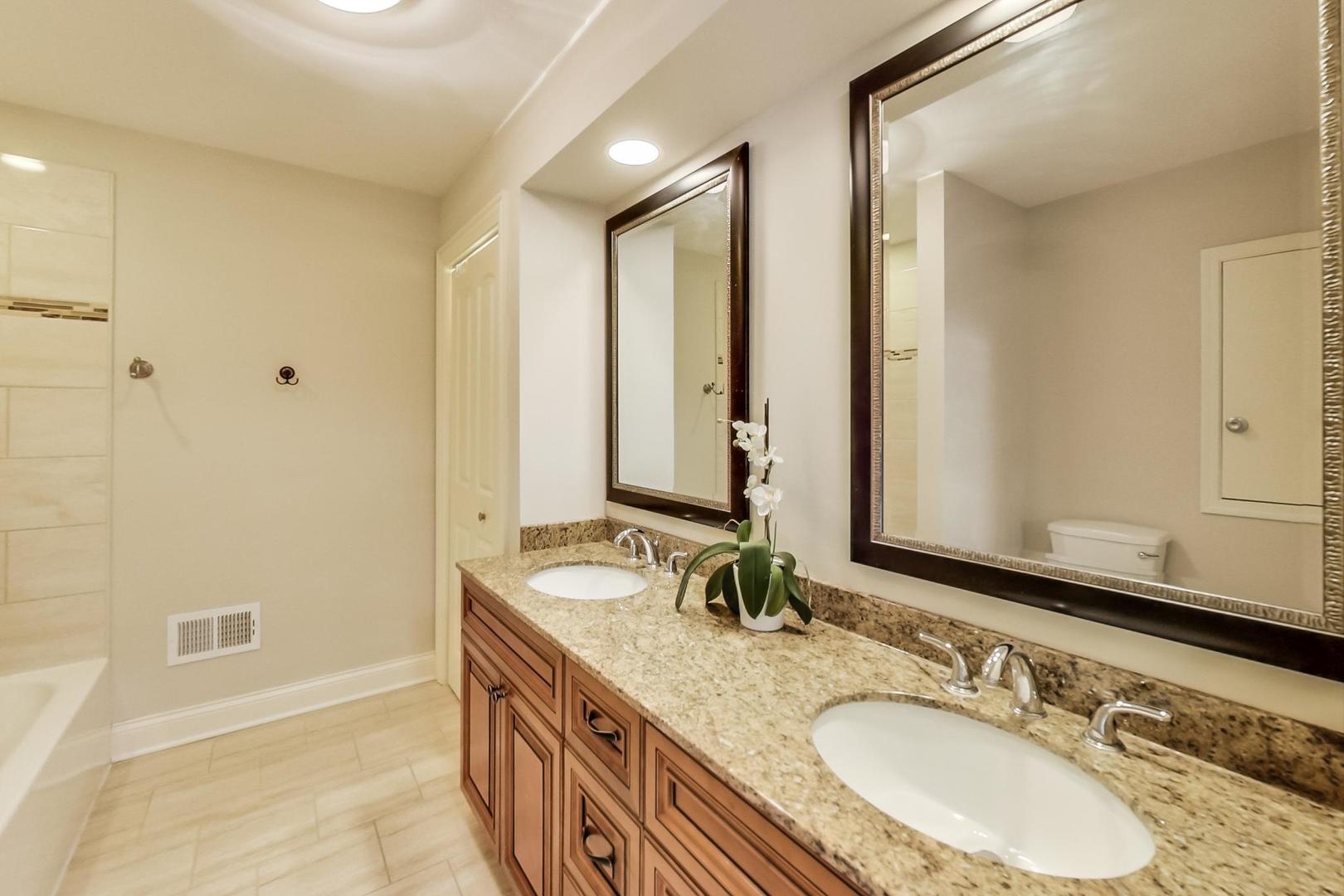 1136 North Greenwood Avenue Park Ridge, IL 60068 - Photo 15 of 30 a bathroom with double vanity sinks a mirror and a shower