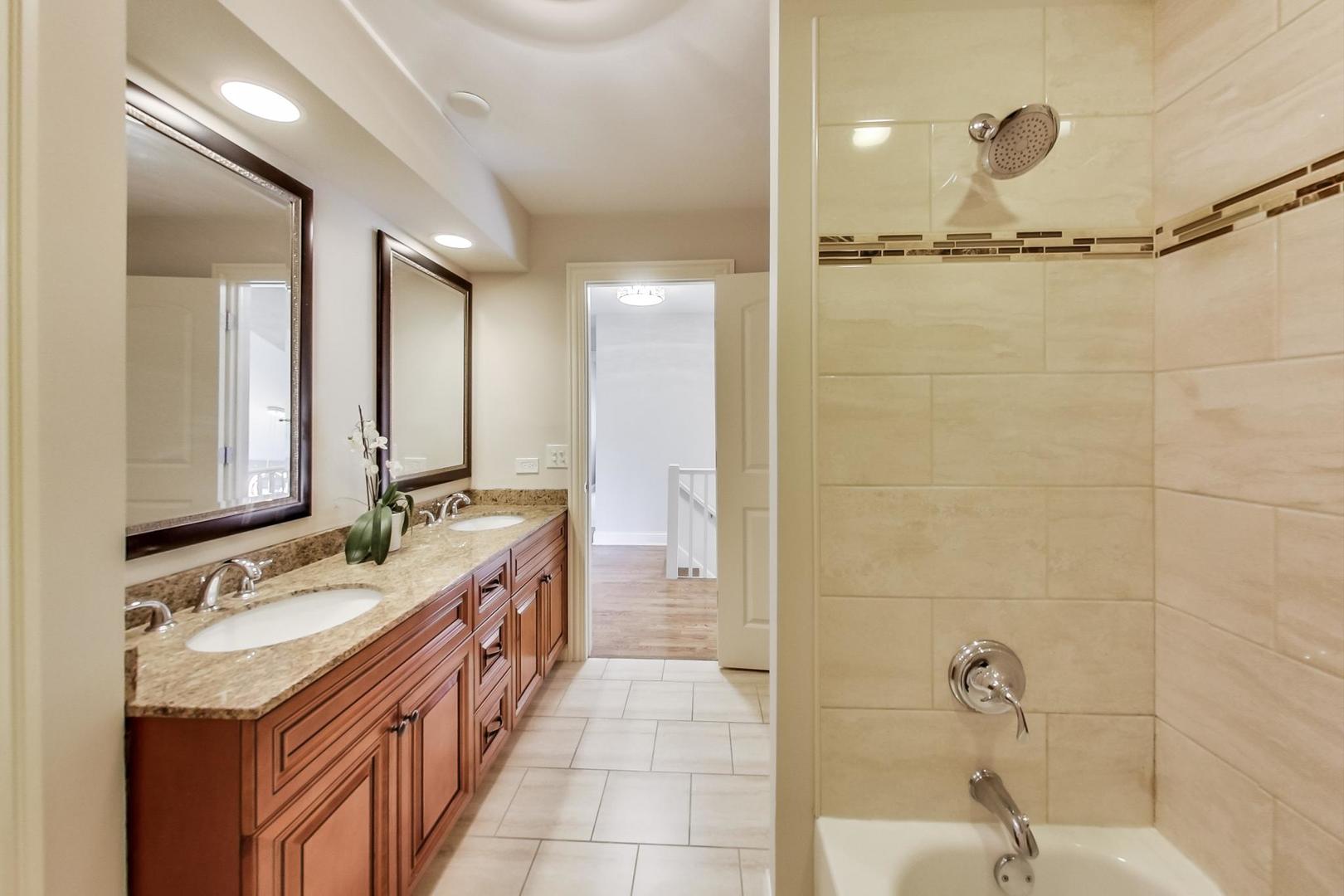 1136 North Greenwood Avenue Park Ridge, IL 60068 - Photo 16 of 30 a bathroom with a double vanity sink a mirror and a bathtub