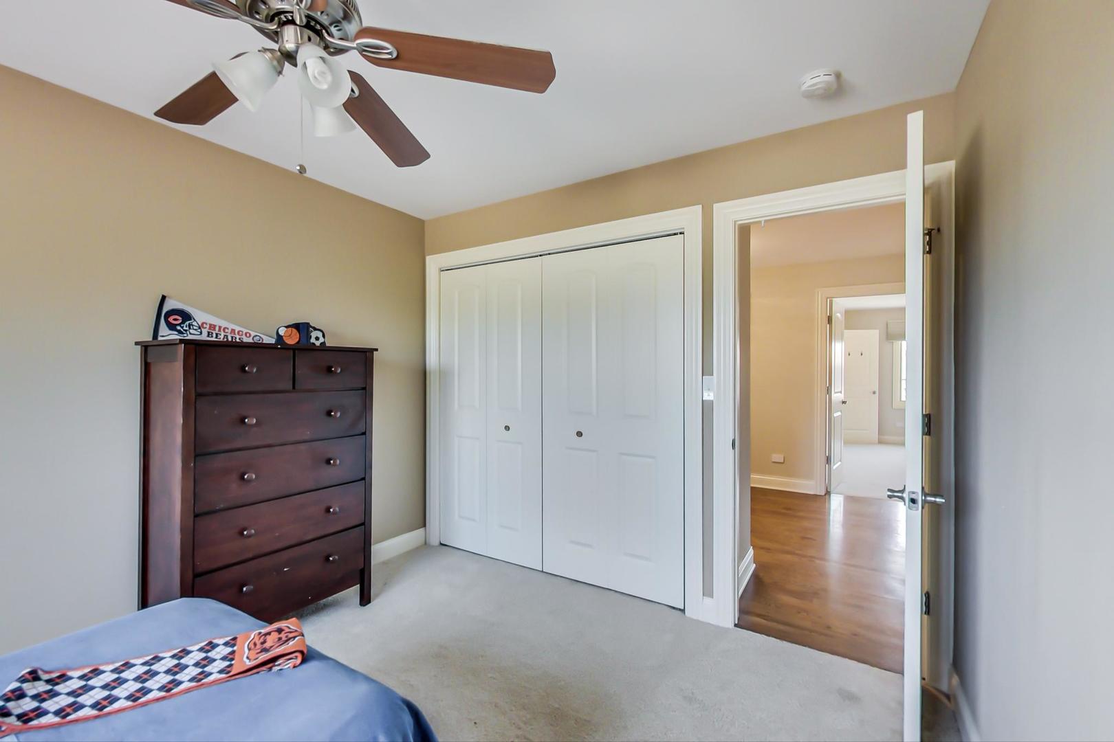 1136 North Greenwood Avenue Park Ridge, IL 60068 - Photo 18 of 30 a view of a bedroom with a dresser and chandelier