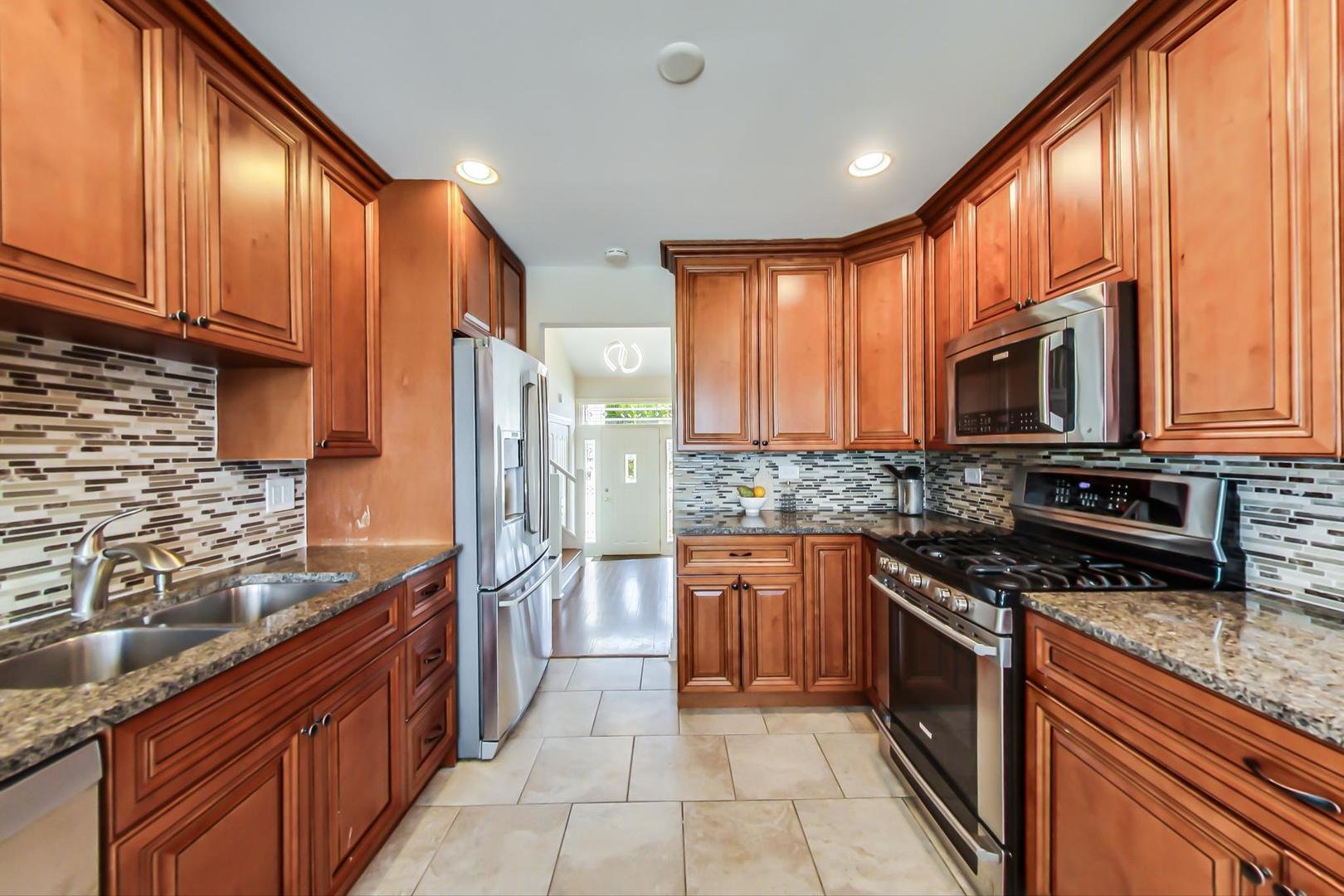 1136 North Greenwood Avenue Park Ridge, IL 60068 - Photo 8 of 30 a kitchen with stainless steel appliances granite countertop wooden cabinets a stove top oven a granite counter top and a view of living room
