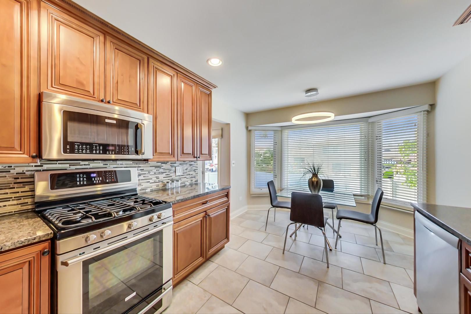 1136 North Greenwood Avenue Park Ridge, IL 60068 - Photo 9 of 30 a kitchen with stainless steel appliances a stove a sink cabinets and a dining table